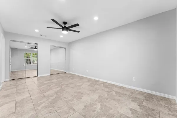 an empty room with closet and windows