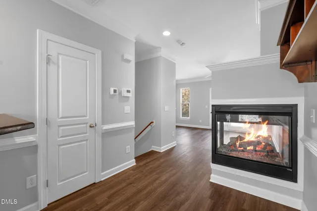 a living room with stainless steel appliances wooden floor and a fireplace