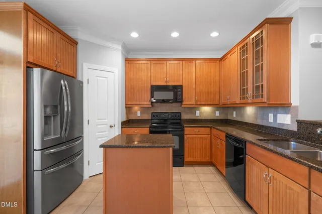 a kitchen with stainless steel appliances granite countertop a refrigerator a stove top oven a sink and dishwasher