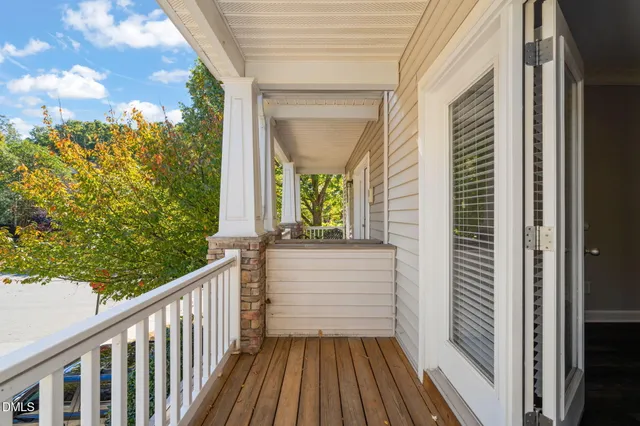 an empty room with wooden floor a ceiling fan and fireplace