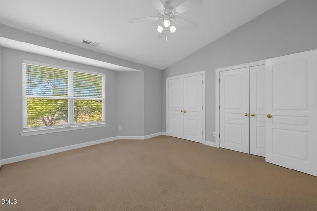 an empty room with a window and a ceiling fan