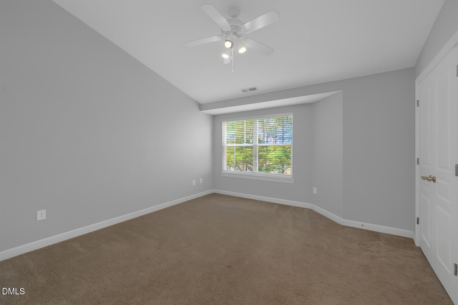 8005 Sycamore Hill Lane Raleigh, NC 27612 - Photo 22 of 31 an empty room with a window and a ceiling fan