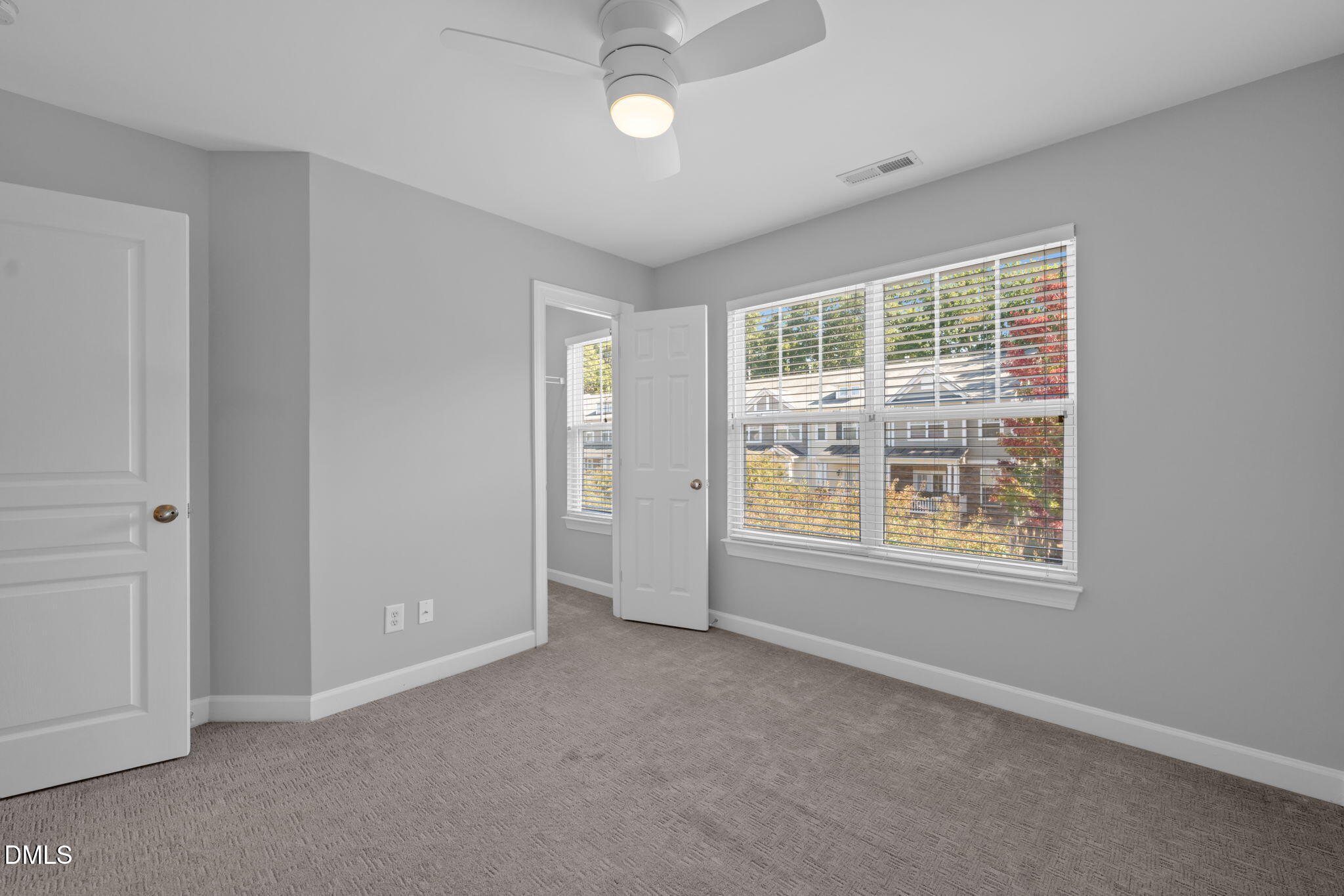 8005 Sycamore Hill Lane Raleigh, NC 27612 - Photo 26 of 31 an empty room with chandelier fan and windows