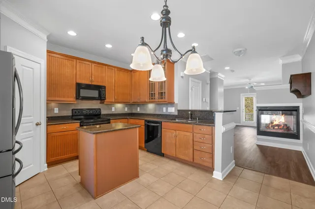 a kitchen with stainless steel appliances granite countertop a refrigerator a sink a stove top oven and a counter top space