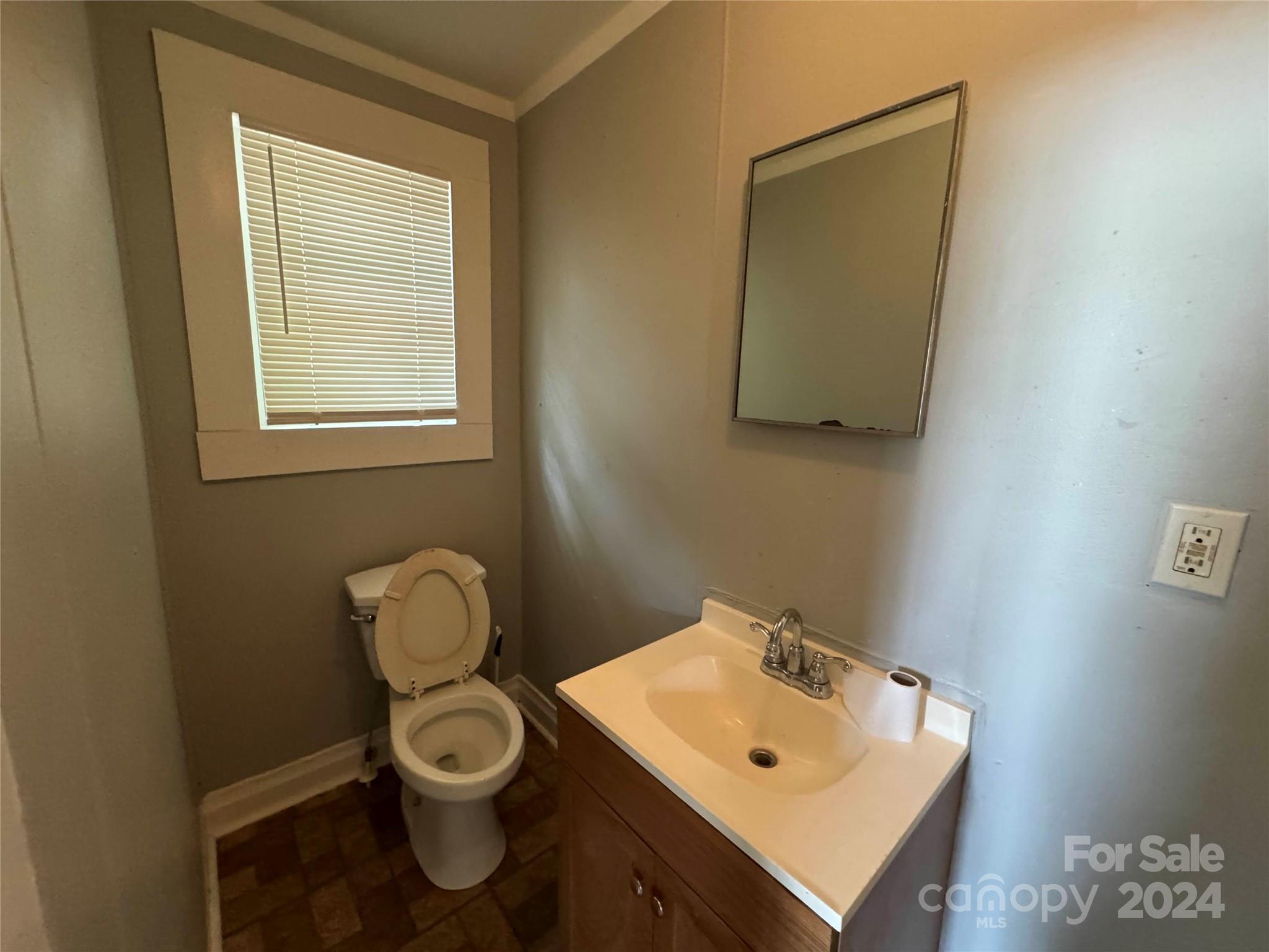 1120 North Ransom Street Gastonia, NC 28052 - Photo 12 of 16 a bathroom with a toilet sink and mirror