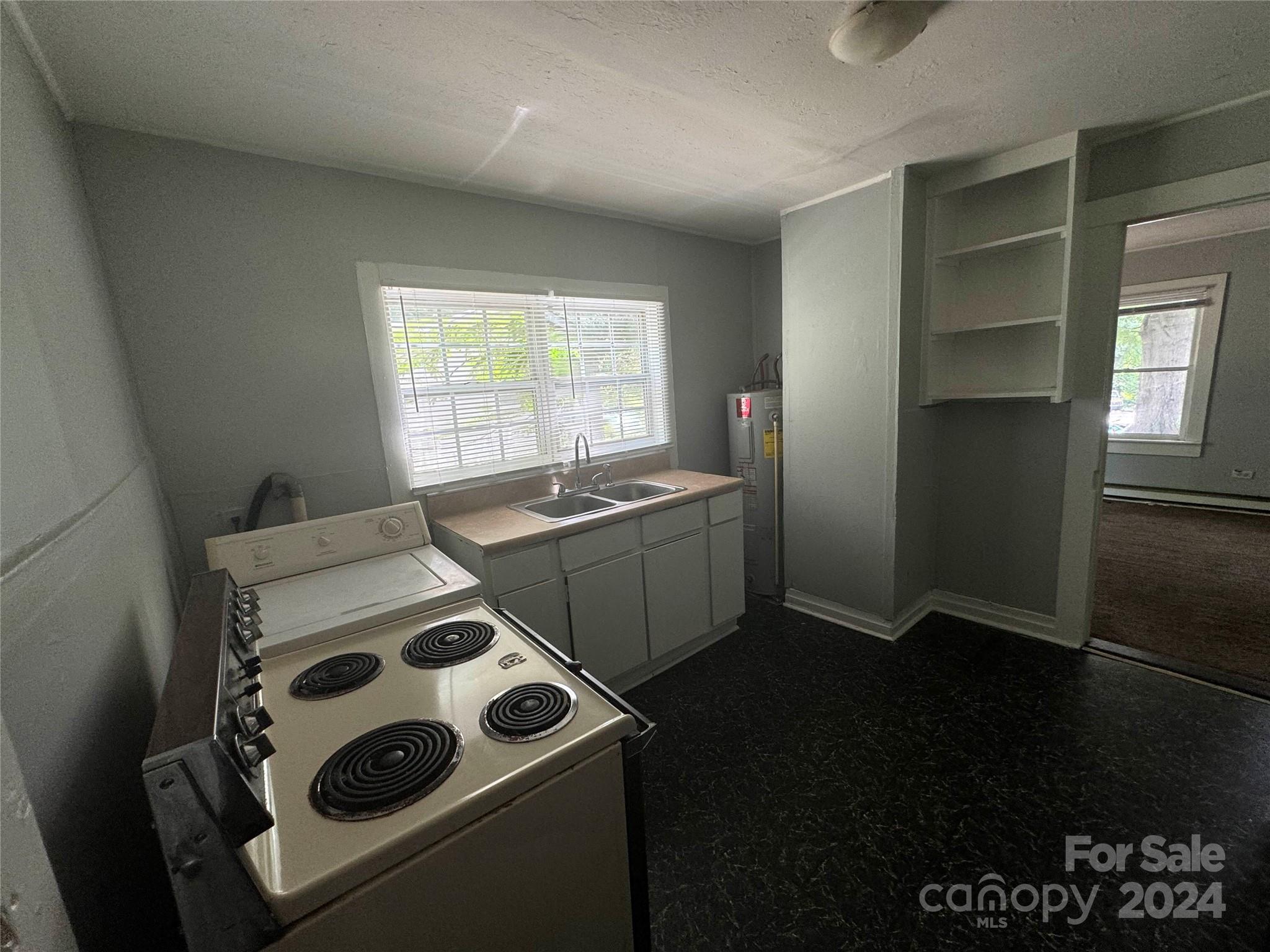 1120 North Ransom Street Gastonia, NC 28052 - Photo 10 of 16 a kitchen that has a sink a stove and a refrigerator