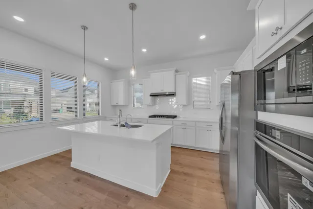 a kitchen with kitchen island a sink stainless steel appliances and window