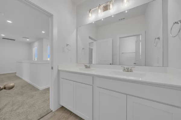 a bathroom with double sink and a mirror