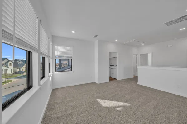 a view of an empty room with a fireplace and window