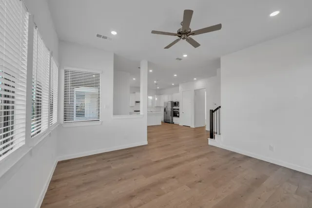 a view of a livingroom with a ceiling fan and wooden floor