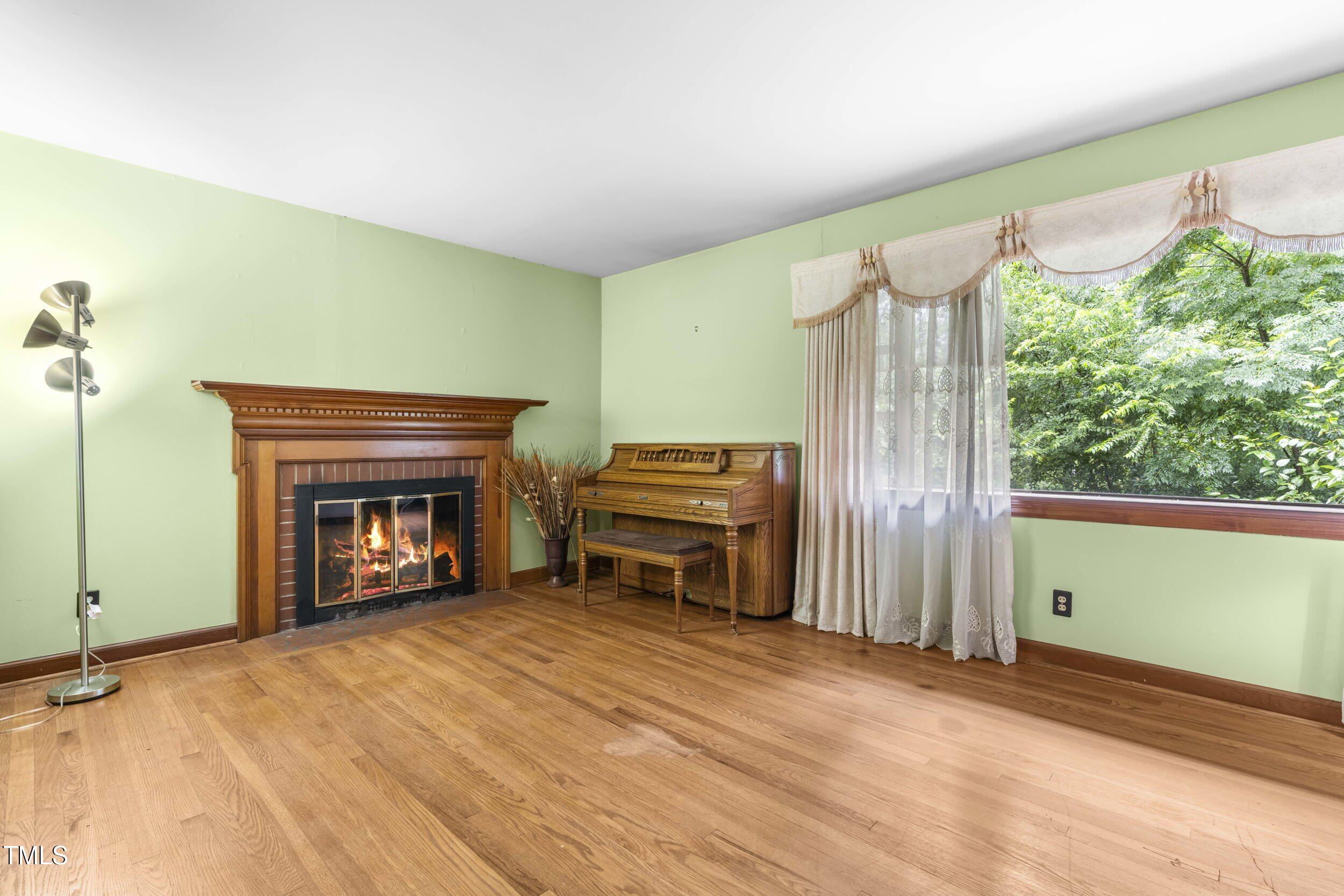 3721 Baugh Street Raleigh, NC 27604 - Photo 5 of 11 a view of an empty room with a fireplace and a window