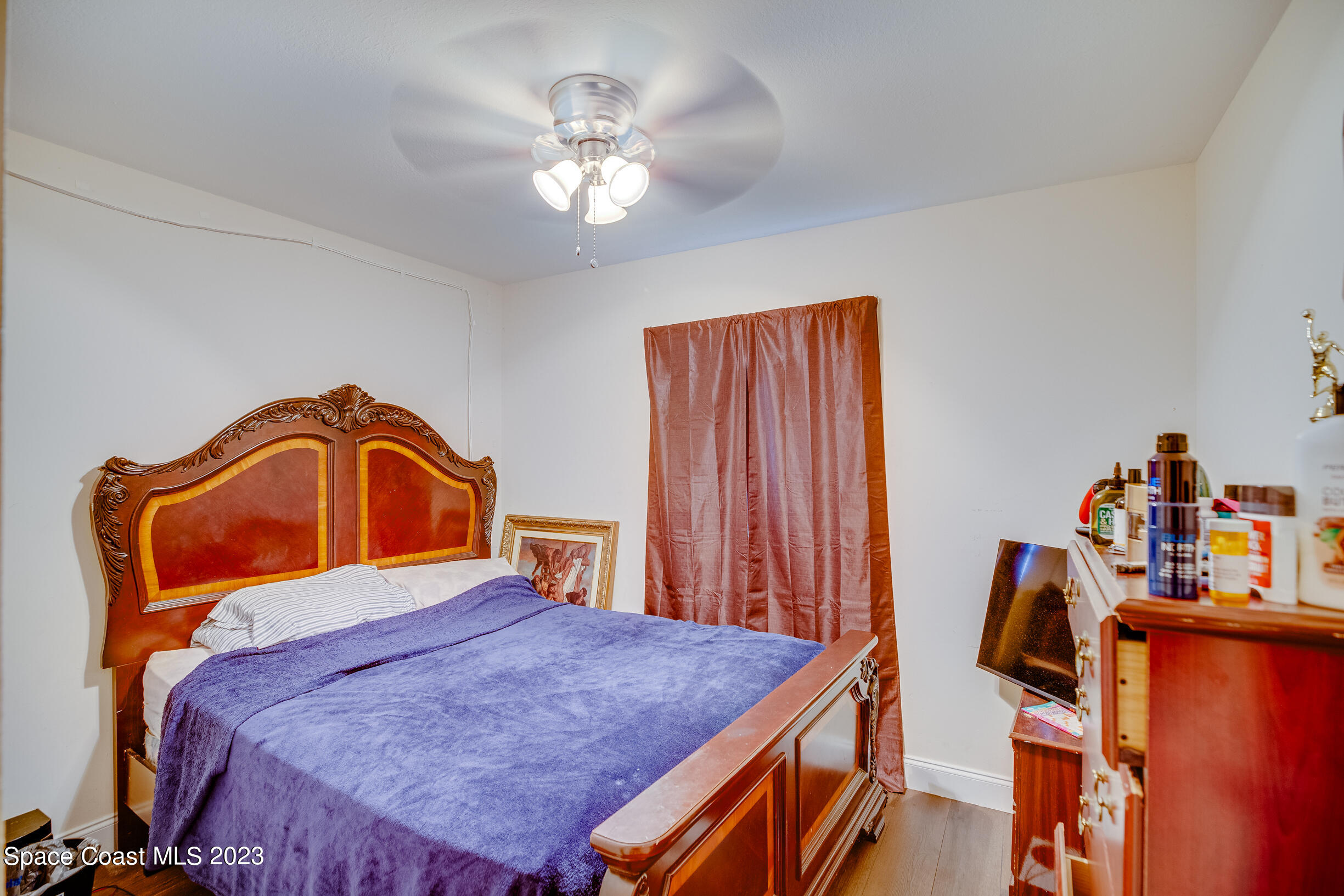 911 Thompson Road Southwest Palm Bay, FL 32908 - Photo 12 of 19 a bedroom with a bed and a chandelier