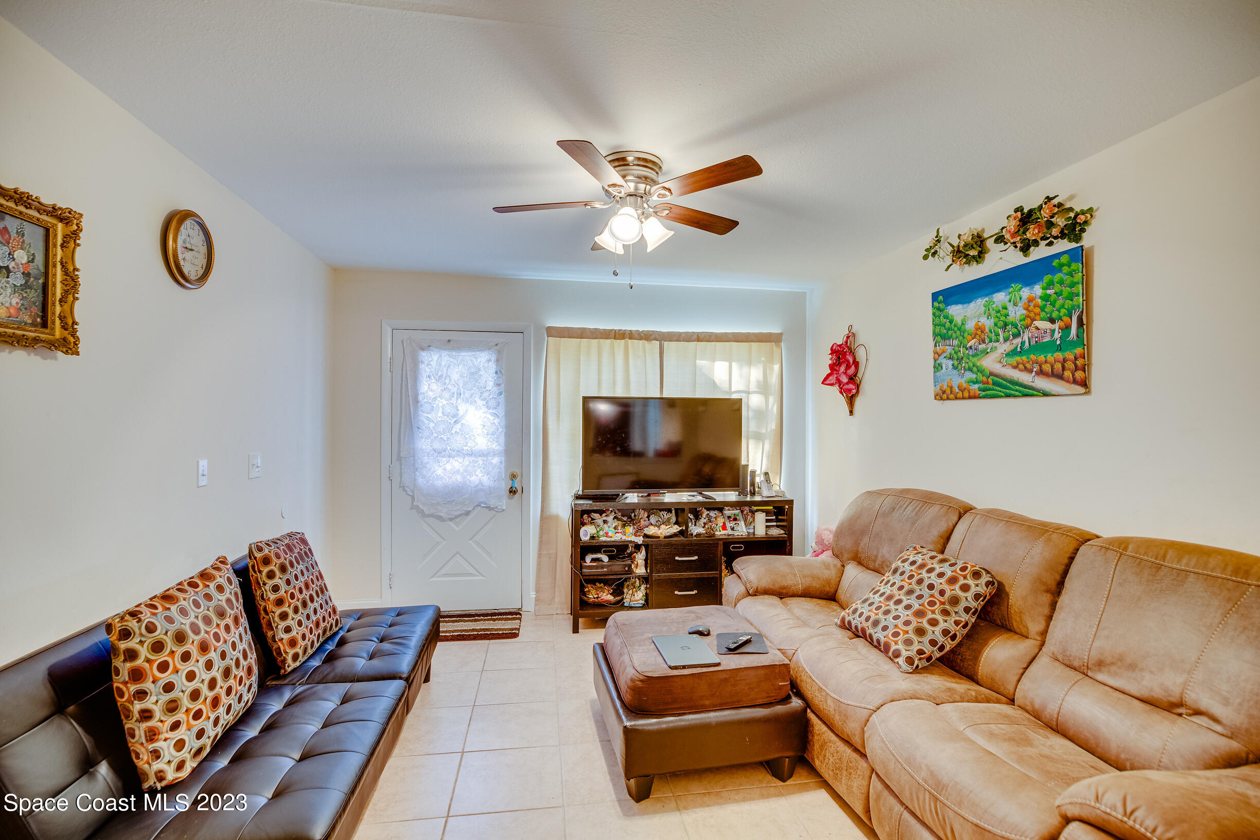 911 Thompson Road Southwest Palm Bay, FL 32908 - Photo 3 of 19 a living room with furniture and a flat screen tv