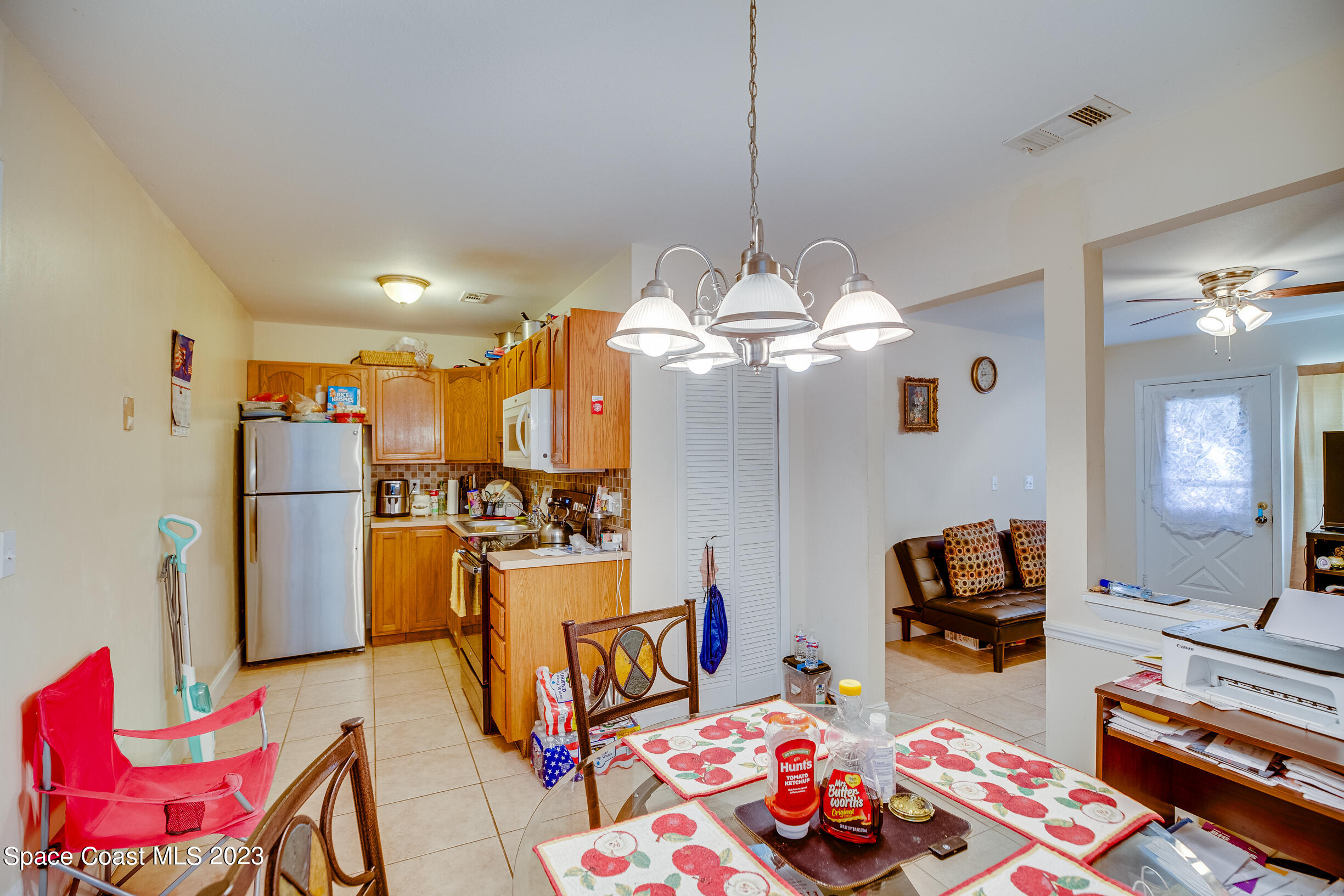 911 Thompson Road Southwest Palm Bay, FL 32908 - Photo 4 of 19 a living room with furniture and a chandelier
