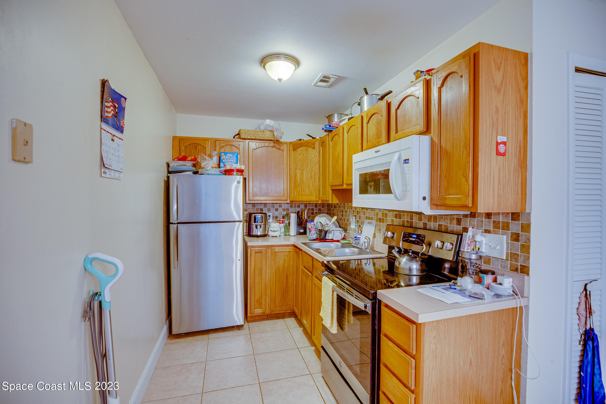 911 Thompson Road Southwest Palm Bay, FL 32908 - Photo 5 of 19 a kitchen with refrigerator a stove a sink and a refrigerator