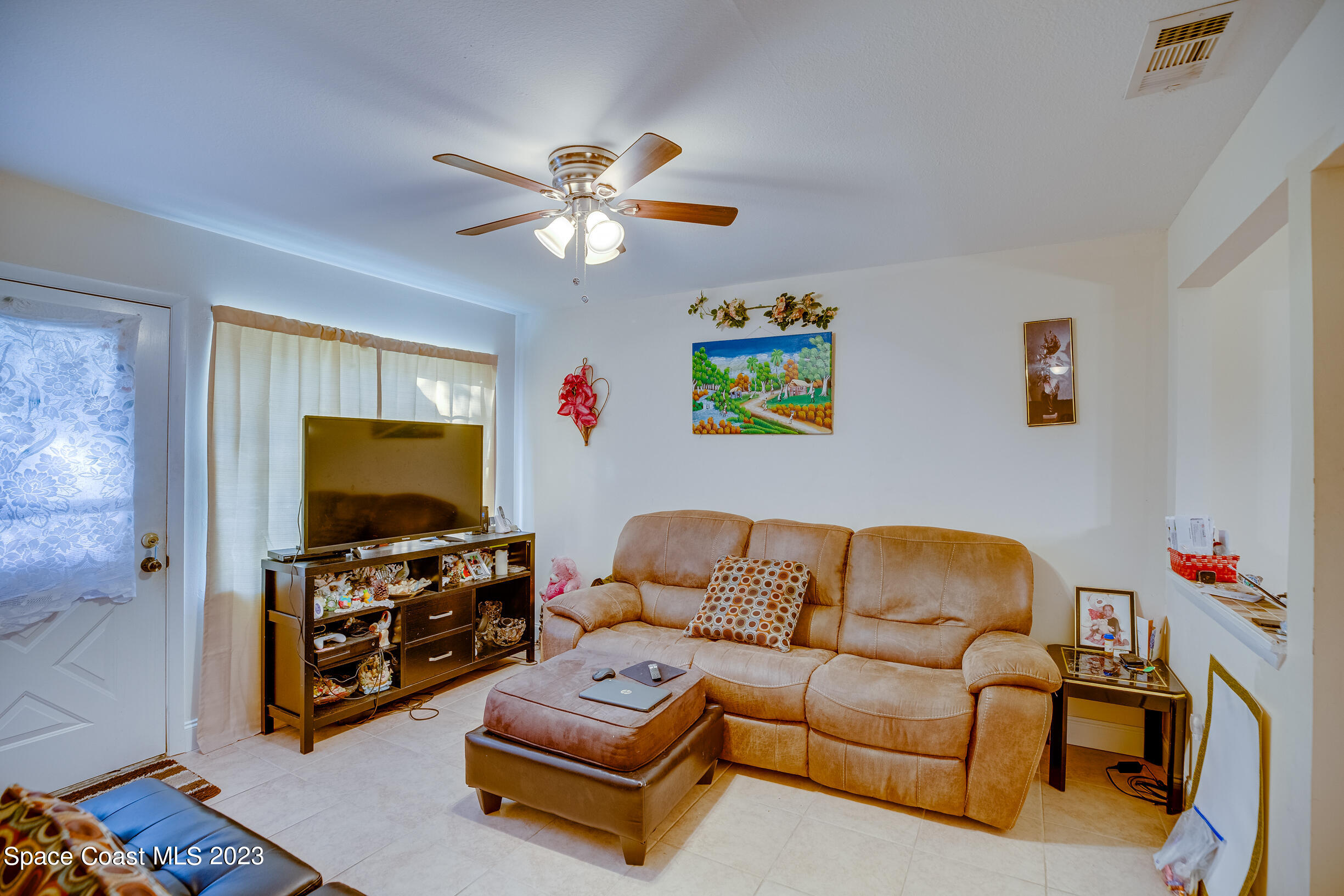 911 Thompson Road Southwest Palm Bay, FL 32908 - Photo 7 of 19 a living room with furniture and a flat screen tv