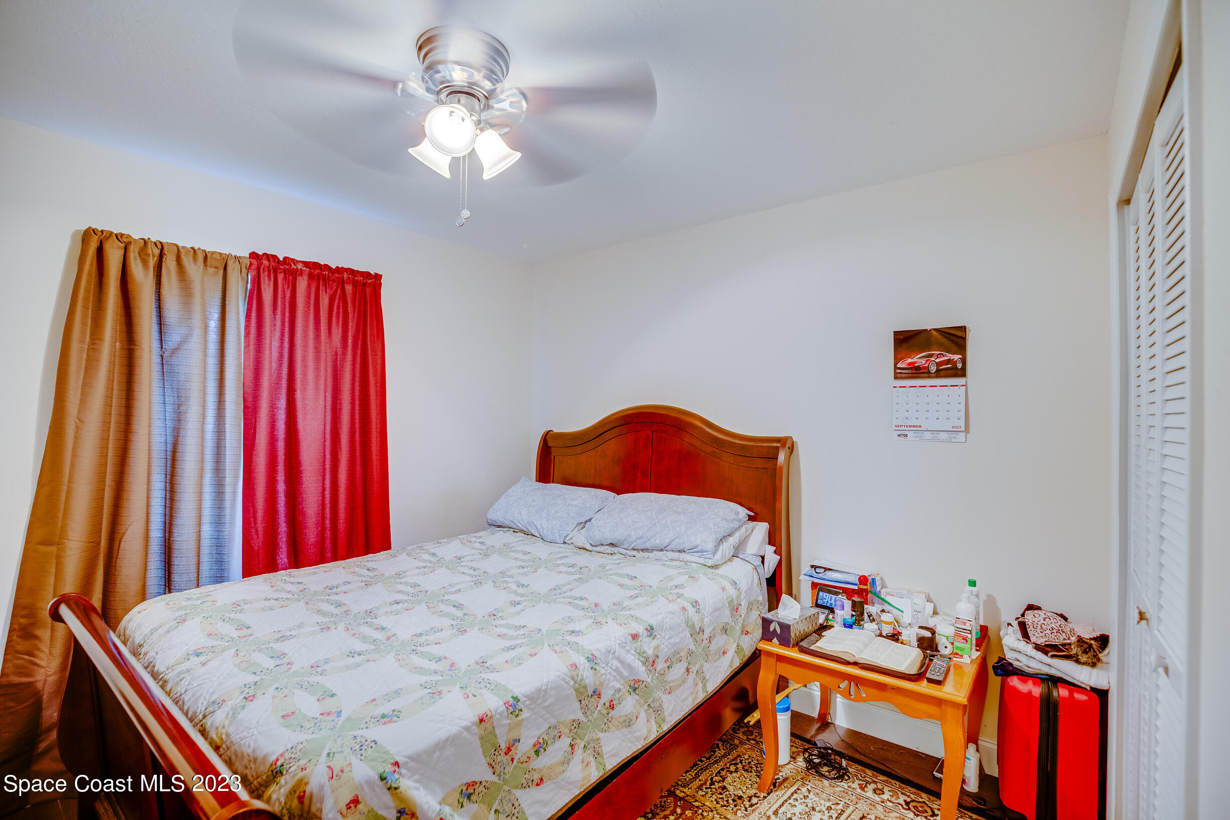 911 Thompson Road Southwest Palm Bay, FL 32908 - Photo 10 of 19 a bedroom with a bed and a chandelier
