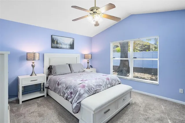 a bedroom with a bed chandelier and a window