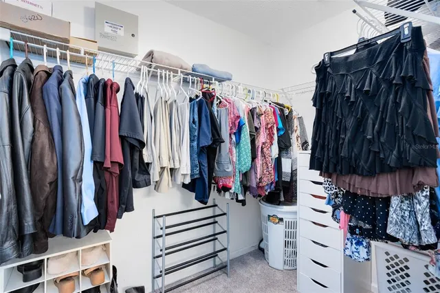 a view of walk in closet with clothes