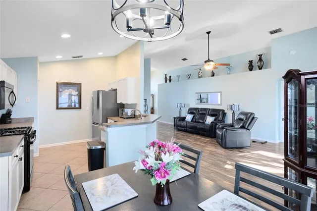 a kitchen with stainless steel appliances granite countertop a sink dishwasher and a flat screen tv