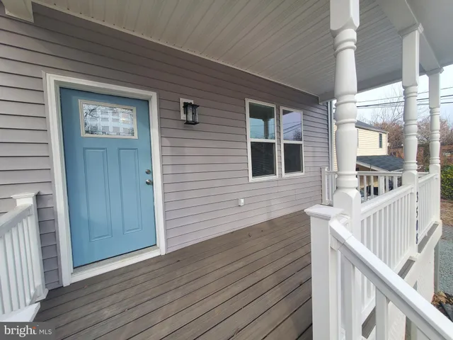 a view of front door deck and wooden floor