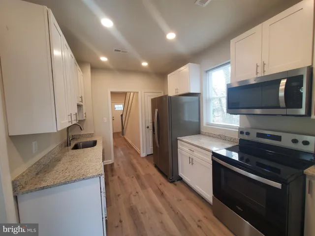 a kitchen with stainless steel appliances granite countertop a stove a refrigerator and a sink