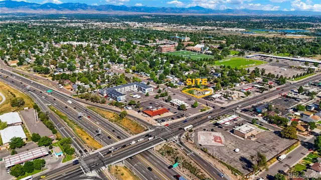 an aerial view of a city with lots of residential buildings and mountain view in back