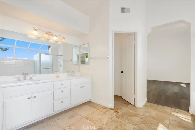 a bathroom with a double vanity sink and a mirror