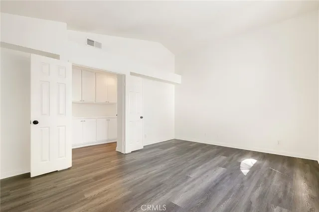 a view of an empty room with wooden floor
