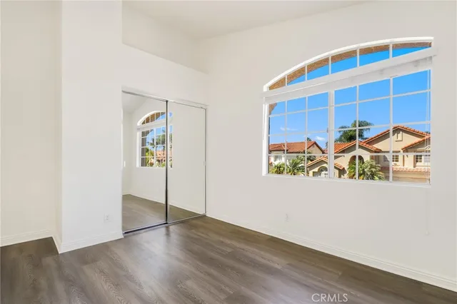 a view of a hallway with wooden floor and table and a painting on the wall