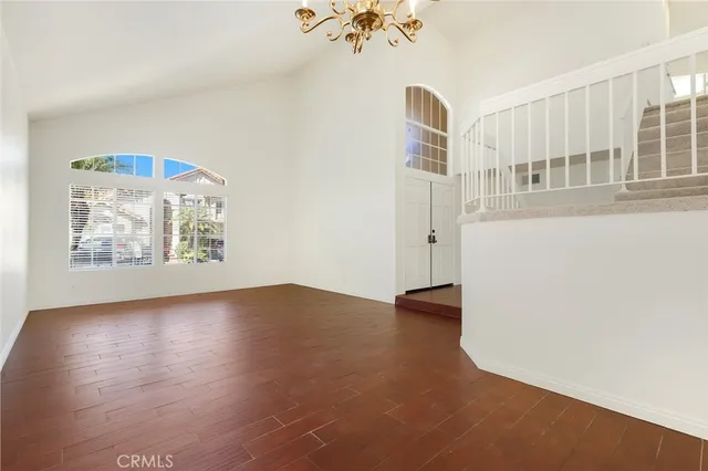 an empty room with cabinet and windows