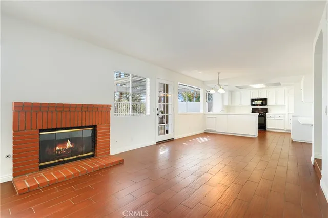 a view of a livingroom with wooden floor and a fireplace
