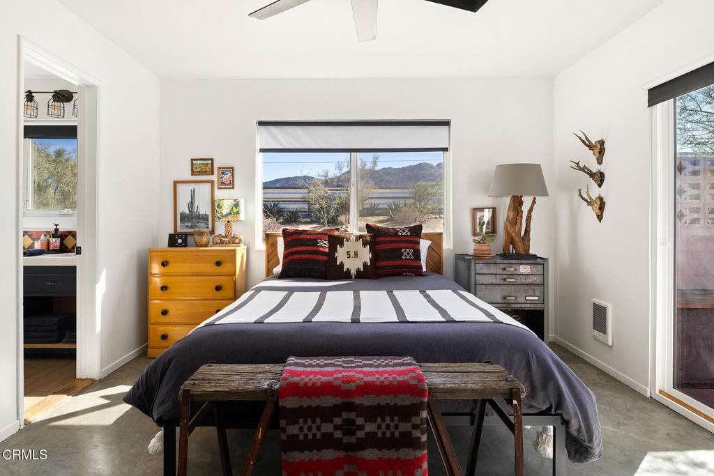 7284 Saddleback Road Joshua Tree, CA 92252 - Photo 13 of 47 a bedroom with a bed and large windows