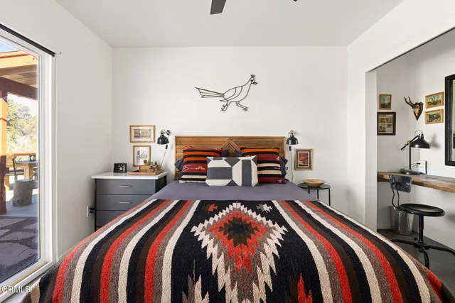 a bedroom with a bed and a lamp with the dresser