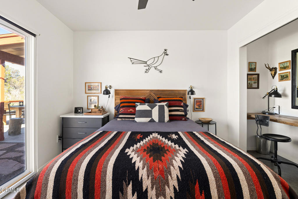 7284 Saddleback Road Joshua Tree, CA 92252 - Photo 21 of 47 a bedroom with a bed and a lamp with the dresser