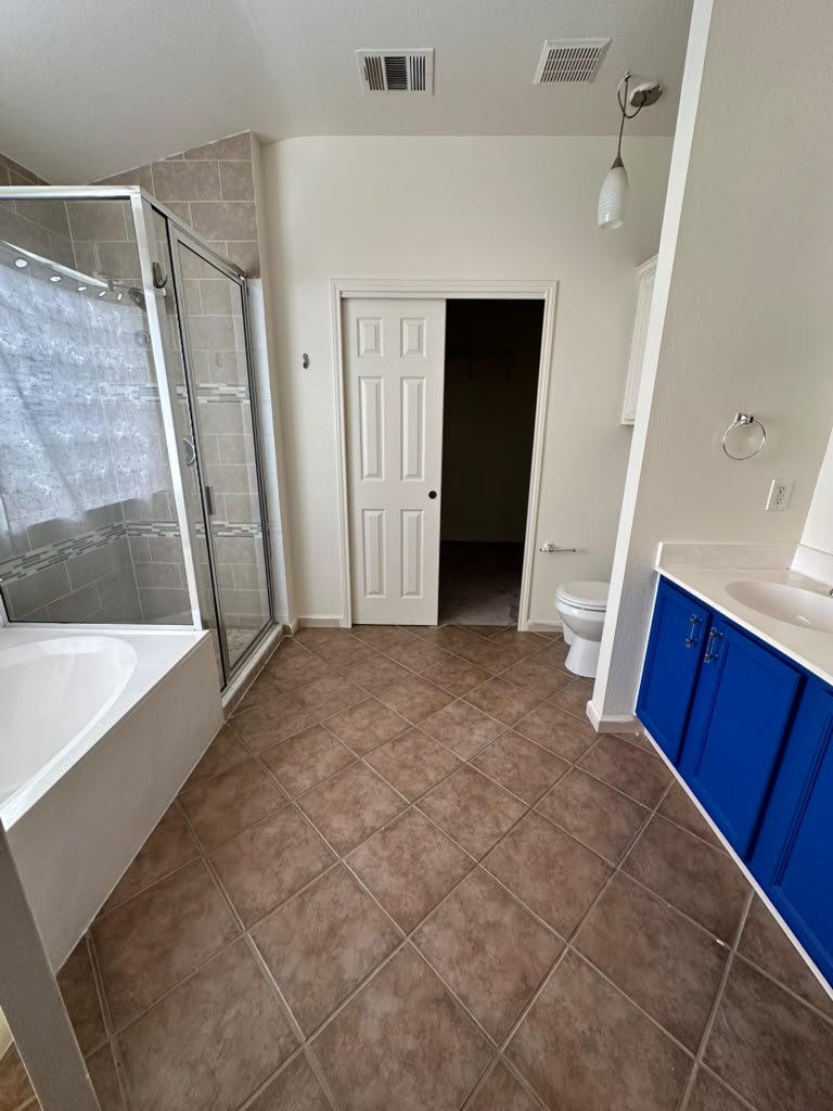 1981 Prairie Rock Way Round Rock, TX 78664 - Photo 16 of 22 Tiled flooring anchors this primary bath complete with a soaking tub and separate shower.