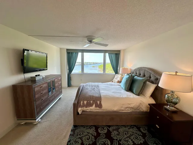 a bedroom with a bed and flat tv screen on the dresser