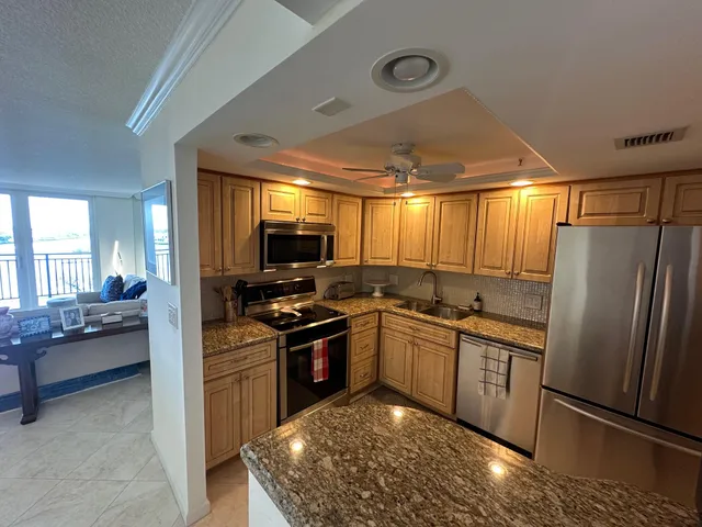a kitchen with stainless steel appliances granite countertop a sink stove and refrigerator