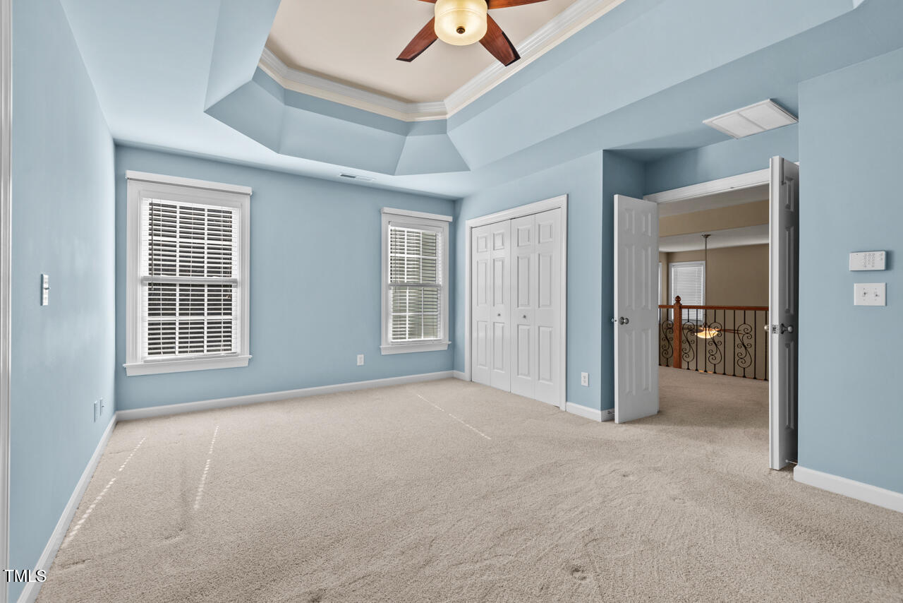 6116 Tiffield Way Wake Forest, NC 27587 - Photo 22 of 39 an empty room with chandelier fan and windows