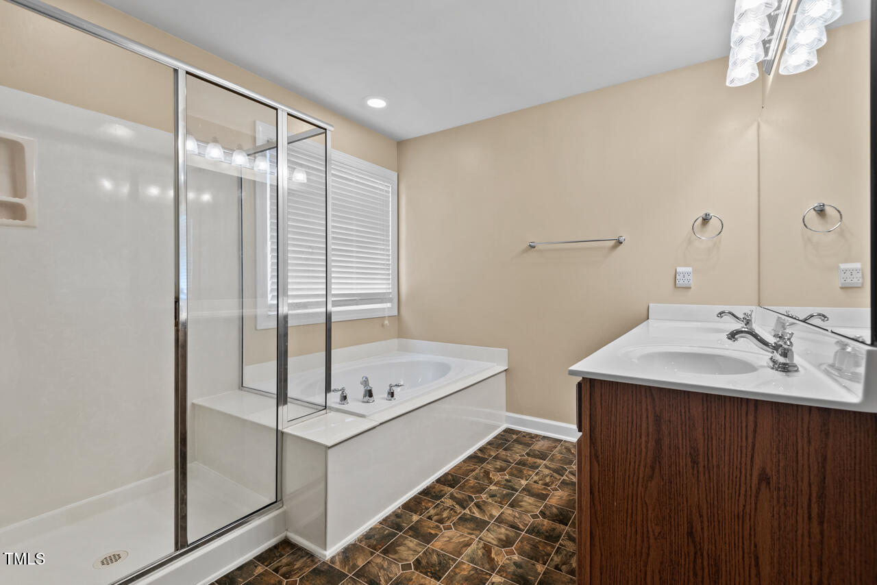 6116 Tiffield Way Wake Forest, NC 27587 - Photo 23 of 39 a bathroom with a tub sink and mirror