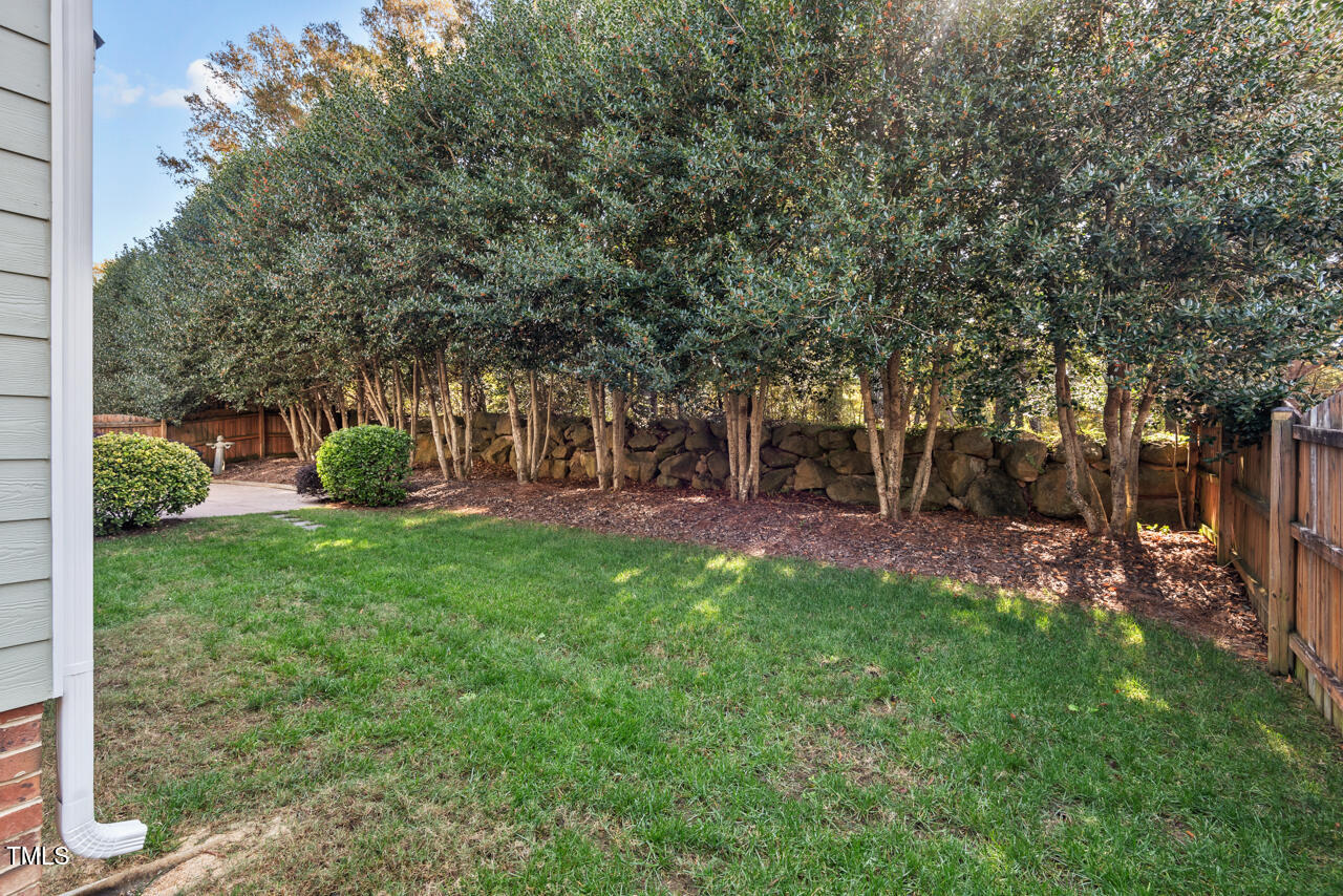 6116 Tiffield Way Wake Forest, NC 27587 - Photo 35 of 39 a view of a backyard with table and chairs potted plants and large tree