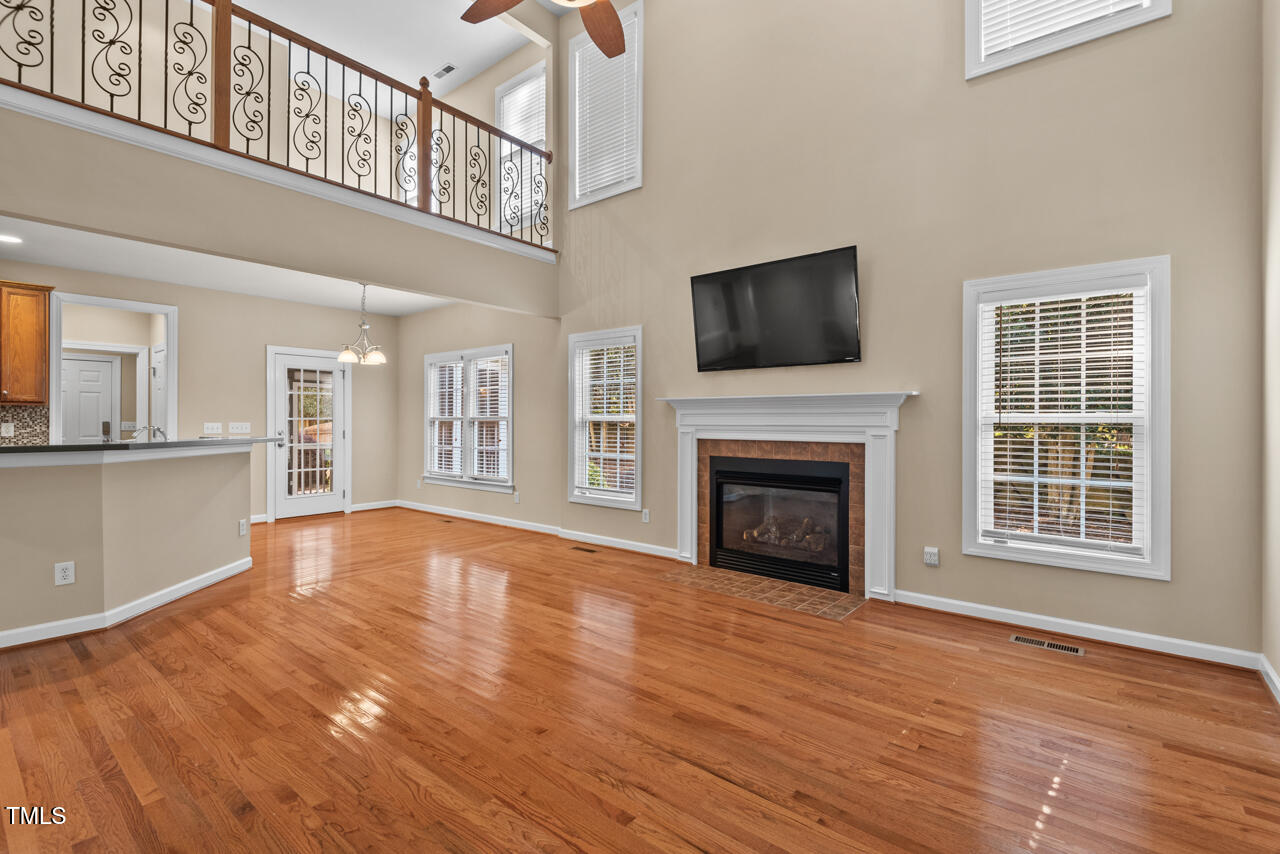 6116 Tiffield Way Wake Forest, NC 27587 - Photo 9 of 39 a view of an empty room with wooden floor fireplace and a window