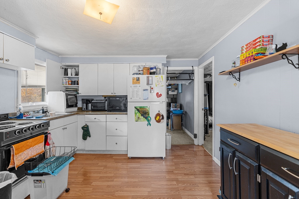 58 Read Avenue Coventry, RI 02816 - Photo 26 of 36 a kitchen with a refrigerator a stove a sink dishwasher and wooden cabinets
