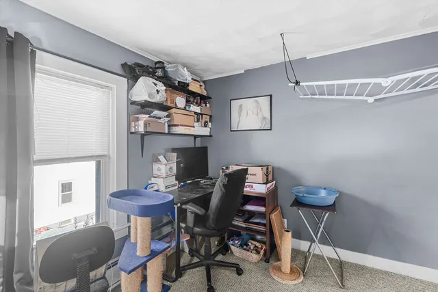 a view of a workspace with furniture and a window