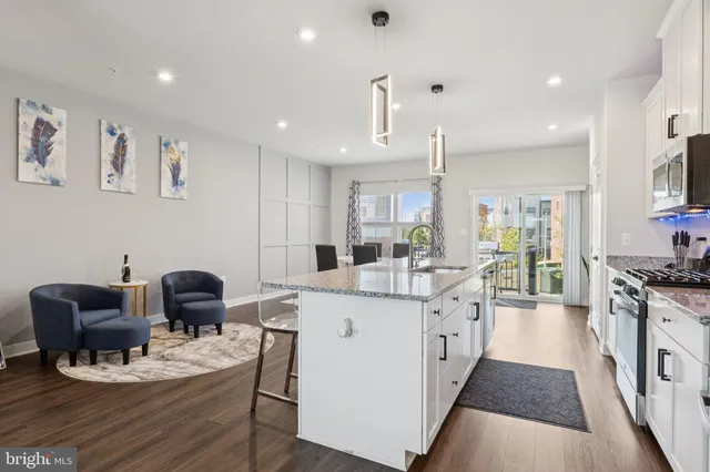 a kitchen with a dining table chairs and wooden floor