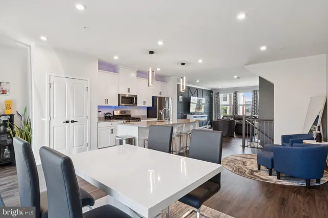 a kitchen with a dining table chairs and white cabinets