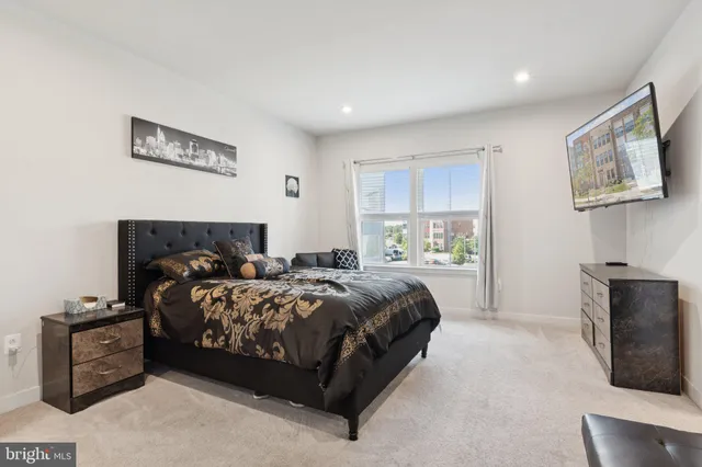 a bedroom with bed couch and window