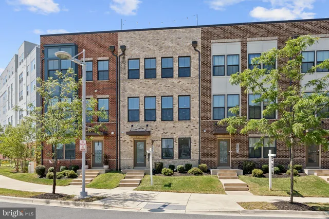 a front view of a building with a garden and plants
