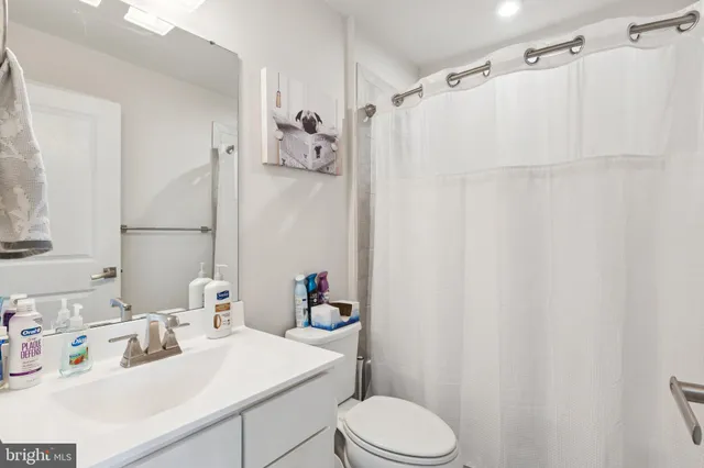 a bathroom with a sink vanity mirror and toilet