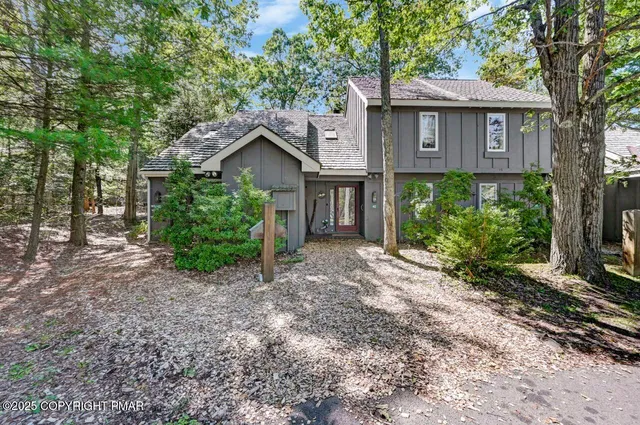 a view of a house with a yard and large tree
